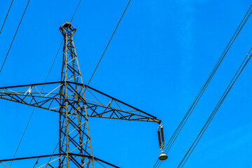 Large electricity pylon power pole with blue sky in Austria.