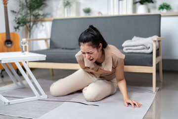 Acute pain and emotional struggle. Woman experiencing abdominal pain on floor.
