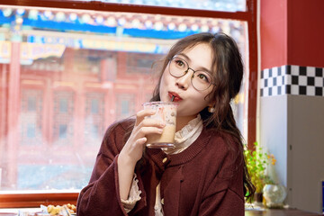 Oriental women eating a lot at the Meiyan hot dog fast food restaurant