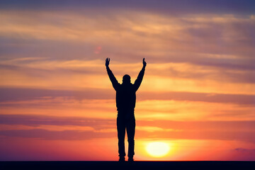 Silhouette of Person Celebrating at Colorful Sunset