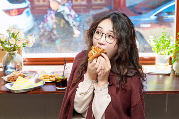 Oriental women eating a lot at the Meiyan hot dog fast food restaurant