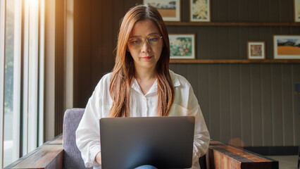 working from home, remote work concept. front view of Asian woman in casual shirt wearing...
