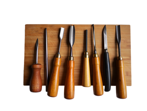 Collection of eight wood carving tools with wooden handles and metal blades arranged on a light brown bamboo cutting board isolated on a transparent background