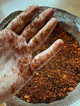 Uno mostrando polvo a base de caf&eacute; y semilla de aguacate triturado, birutas mezcladas formando una base crocante en un embase de aluminio para horno, comprimido tipo galleta, abono plantas