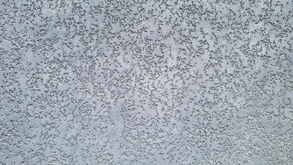 Rough textured gray stucco wall surface with irregular plaster pattern. Construction and architectural background. Wall texture. Front view