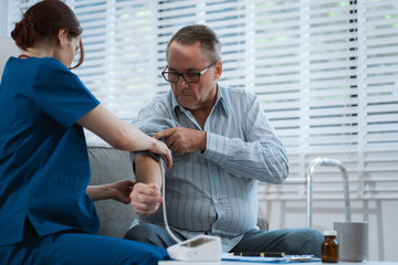 doctor checking man blood pressure at clinic and filling patient history.