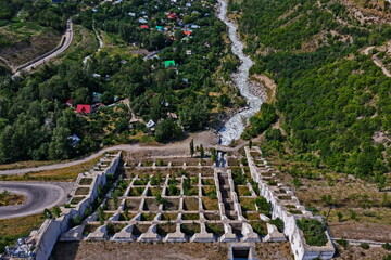 A protective dam in the Talgar gorge. A mountainous area with different vegetation and a river.
