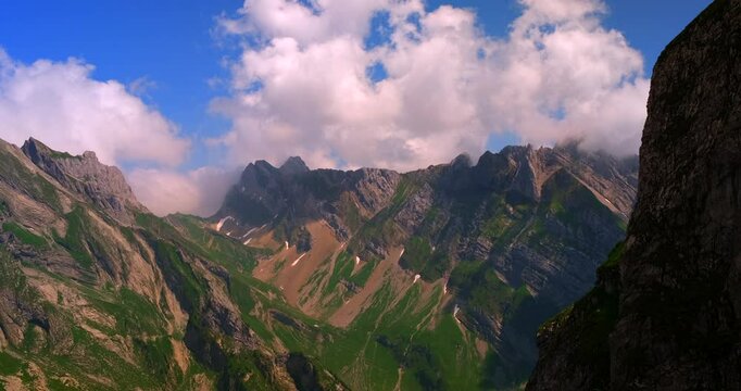 Stunning view of mountains and clouds during a bright day in the alpine region