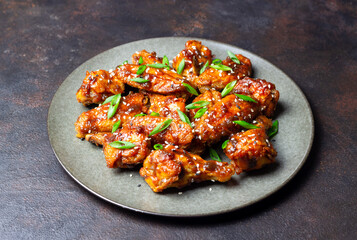 Chicken wings in teriyaki sauce with sesame and onion. Asian food.