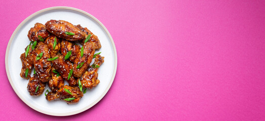 Chicken wings in teriyaki sauce with sesame and onion. Asian food.