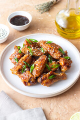 Chicken wings in teriyaki sauce with sesame and onion. Asian food.