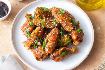 Chicken wings in teriyaki sauce with sesame and onion. Asian food.