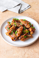 Chicken wings in teriyaki sauce with sesame and onion. Asian food.