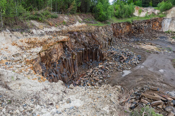 Basaltic columns on wall of basalt quarry in overcast day