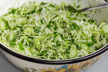Green vegetable salad in big kitchen bowl, fragment close-up