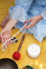 Calm person holds meditation beads. Image is used for mindfulness, spiritual practice, or wellness content in peaceful settings.