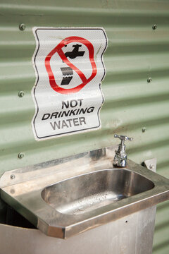 Do Not Drink Water sign above basin outside roadside toilet