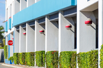 The facade of a building with a line of pillars and hedges