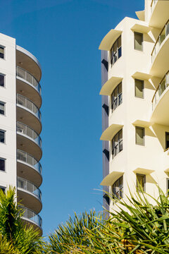Two apartment blocks facing one another against a blue sky