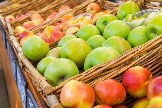 Baskets full of different types of apples at markets