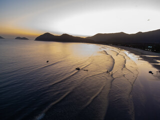 magnificent golden hour sunset on beach with forest mountains