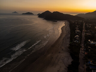 magnificent golden hour sunset on beach with forest mountains