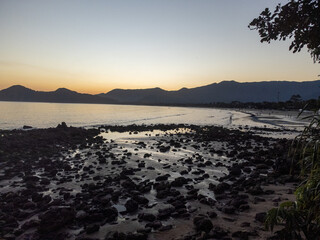 Incredible orange sunset on a beach in the middle of the forest