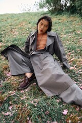 Stylish young man embraces nature in a chic grey outfit surrounded by blossoms