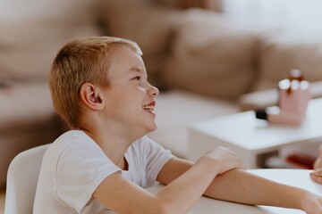 Young mother helps her hard-of-hearing son with schoolwork at home. A natural, heartfelt moment of...