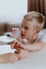 Young mother helps her hard-of-hearing son with schoolwork at home. A natural, heartfelt moment of...