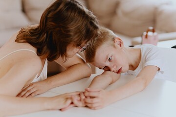 Young mother helps her hard-of-hearing son with schoolwork at home. A natural, heartfelt moment of...