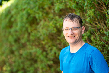 Portrait of a 46 yo man with glasses against a green background in Ternat, Flemish Brabant, Belgium