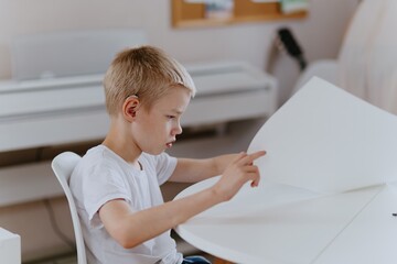 Young mother helps her hard-of-hearing son with schoolwork at home. A natural, heartfelt moment of...