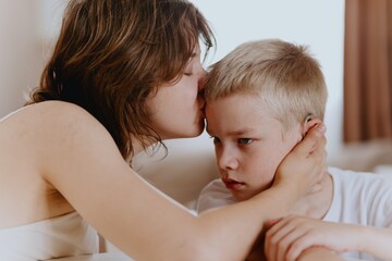 Young mother helps her hard-of-hearing son with schoolwork at home. A natural, heartfelt moment of...