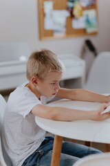 Young mother helps her hard-of-hearing son with schoolwork at home. A natural, heartfelt moment of...