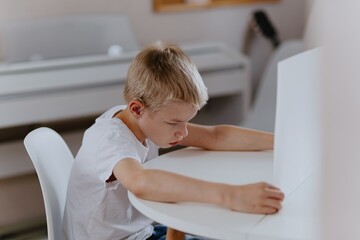Young mother helps her hard-of-hearing son with schoolwork at home. A natural, heartfelt moment of...