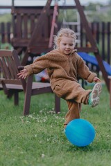 Beautiful 3-year-old girl playing on a neighborhood playground swinging, running on the grass, and enjoying fresh air. A joyful, natural moment full of real emotions and unaltered beauty