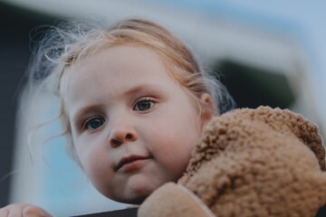 Beautiful 3-year-old girl playing on a neighborhood playground swinging, running on the grass, and enjoying fresh air. A joyful, natural moment full of real emotions and unaltered beauty