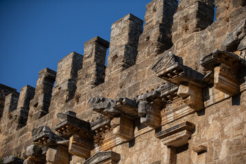 Part of the stone wall of the ancient amphitheater with architectural elements.