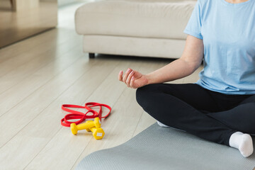 Yoga mindfulness meditation. Senior mature woman practicing yoga at home. Hands in chin mudra...