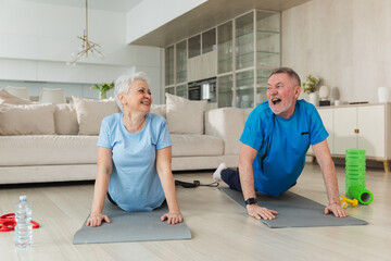 Fitness workout training. Senior adult mature healthy fit couple doing sports exercise on yoga mat on floor at home. Mid age old husband wife have training workout. Health care healthy lifestyle