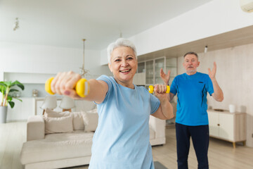 Fitness workout training. Senior woman picking up dumbbells. Old adult mature healthy lady doing...