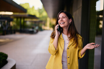 Smiling Woman Talking On Mobile Phone Outdoors During Daytime