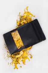 Black packaging with herbal tea, mockup. Soothing herbal tea. A mixture of dry yellow leaves and...
