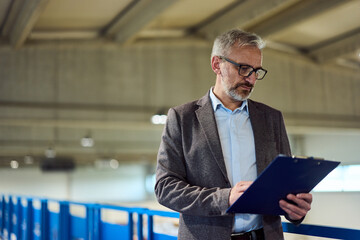 Business Professional Reviewing Documents in an Industrial Office Environment