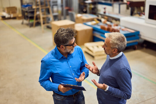 Two Colleagues Discussing Work in an Industrial Setting with a Collaborative Approach