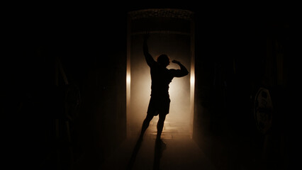 silhouette of a athletes posing, bodybuilder in a dark room