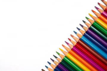 vibrant collection of colored pencils is neatly aligned on a blank white surface, showcasing a variety of hues perfect for drawing, coloring, and crafting artistic designs