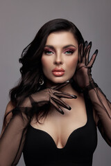 model showcases a sophisticated look, featuring bold makeup and stylish sheer gloves. composition...