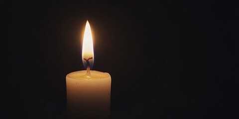 Single candle flame radiates warmth in a dark setting, creating a peaceful atmosphere.